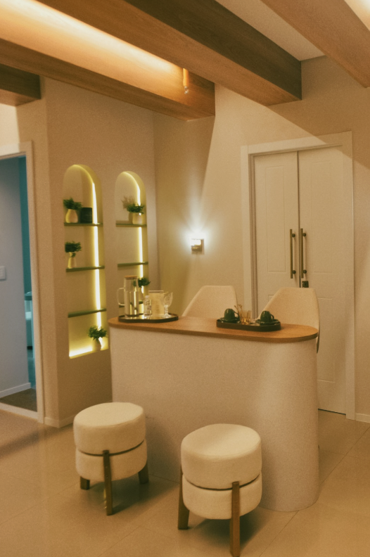 Recepção da clínica, com bancada curva, banquetes estofados e nichos arqueados iluminados